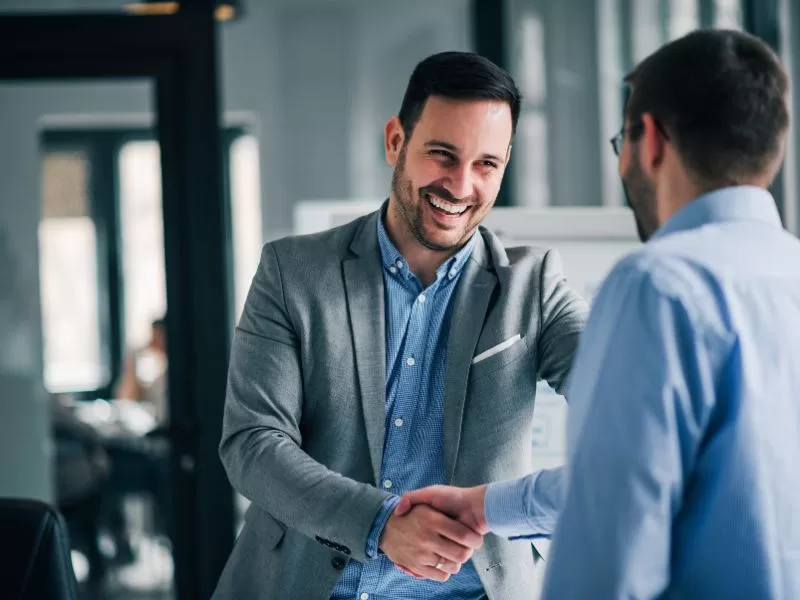 Two colleagues shaking hands over a cybersecurity partnership